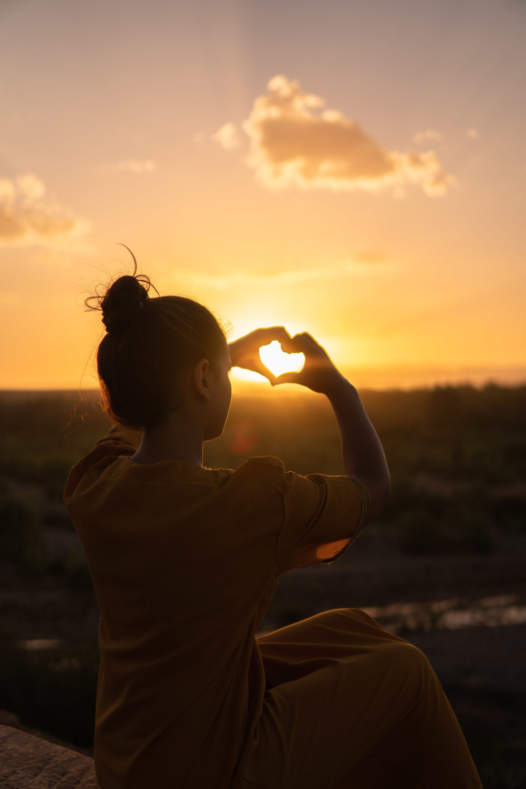 woman-sitting-while-showing-heart-sign-hands-1535288